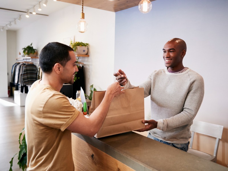 Man serving customer at the counter in a clothing store stock photo