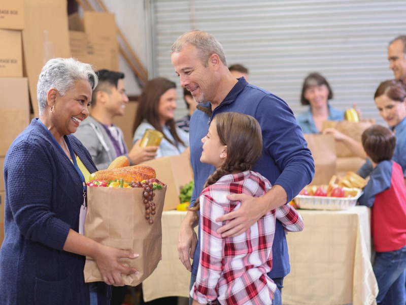 Multi-ethnic group of volunteers work at food bank. stock photo