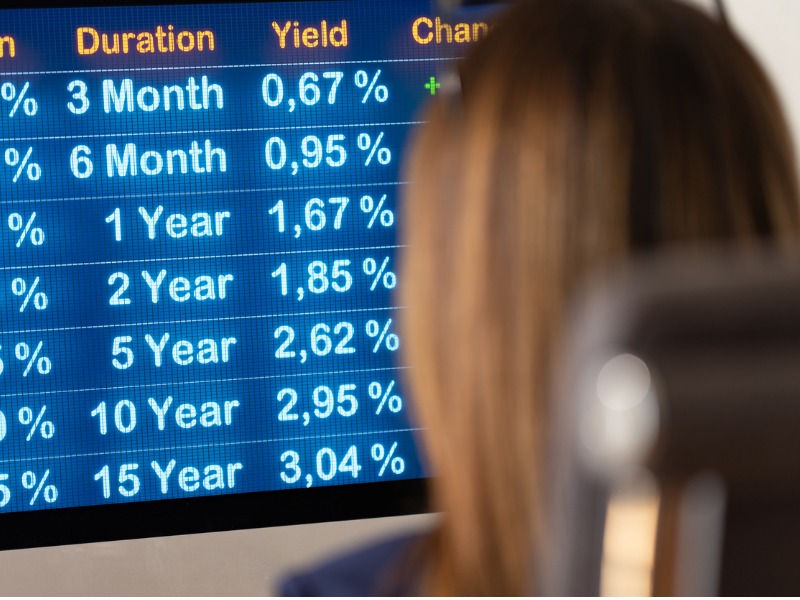 Businesswoman siting at the desk and looks the current interest rates on the Screen. stock photo