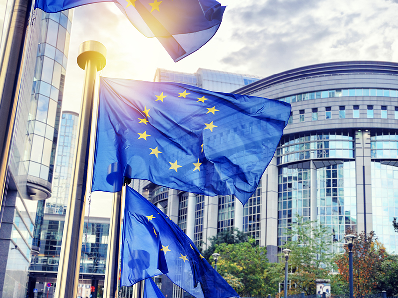 EU flags waving in front of European Parliament building. Brussels, Belgium