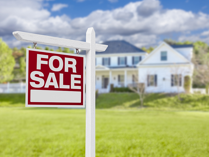 Home For Sale Real Estate Sign in Front of Beautiful New House.