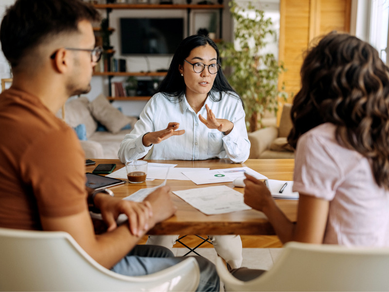 Young couple getting advice from a financial expert around an office table