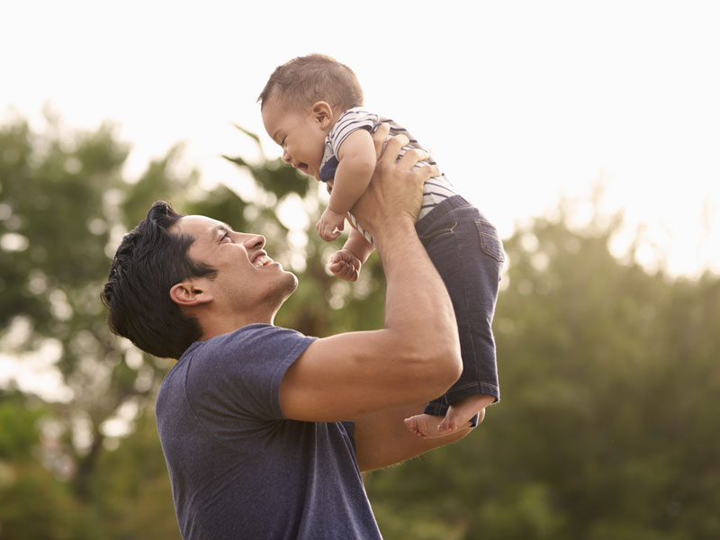 Young father holding his baby both smiling