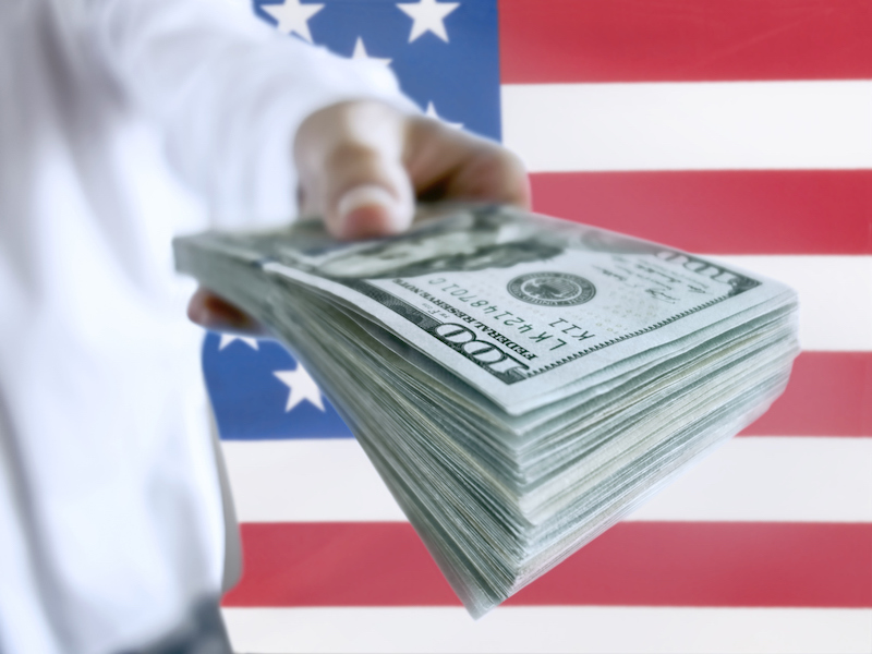 American businessman holding a pile of 100 dollar bills