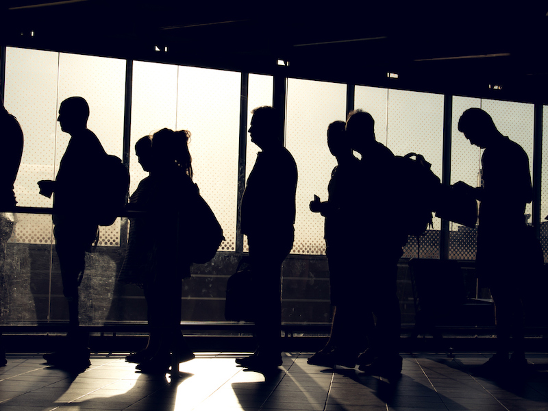 people are waiting in the aterminal with their silhouette reverse lighted image