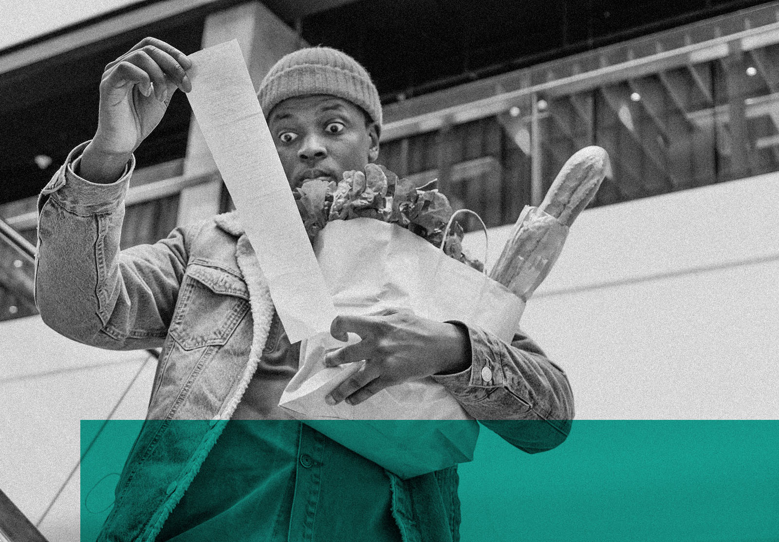 Shocked African-American man looks at grocery receipt total