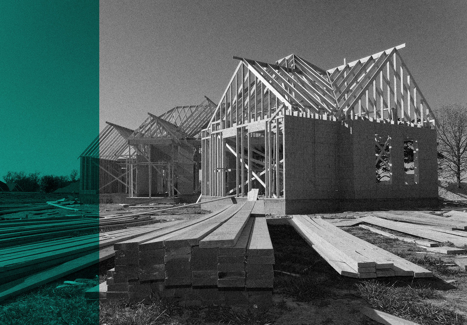 New home under construction with wood, trusses and supplies against blue sky