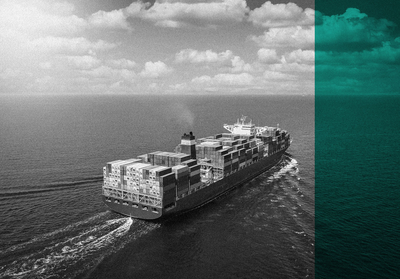 A large container cargo ship travels over calm, blue ocean